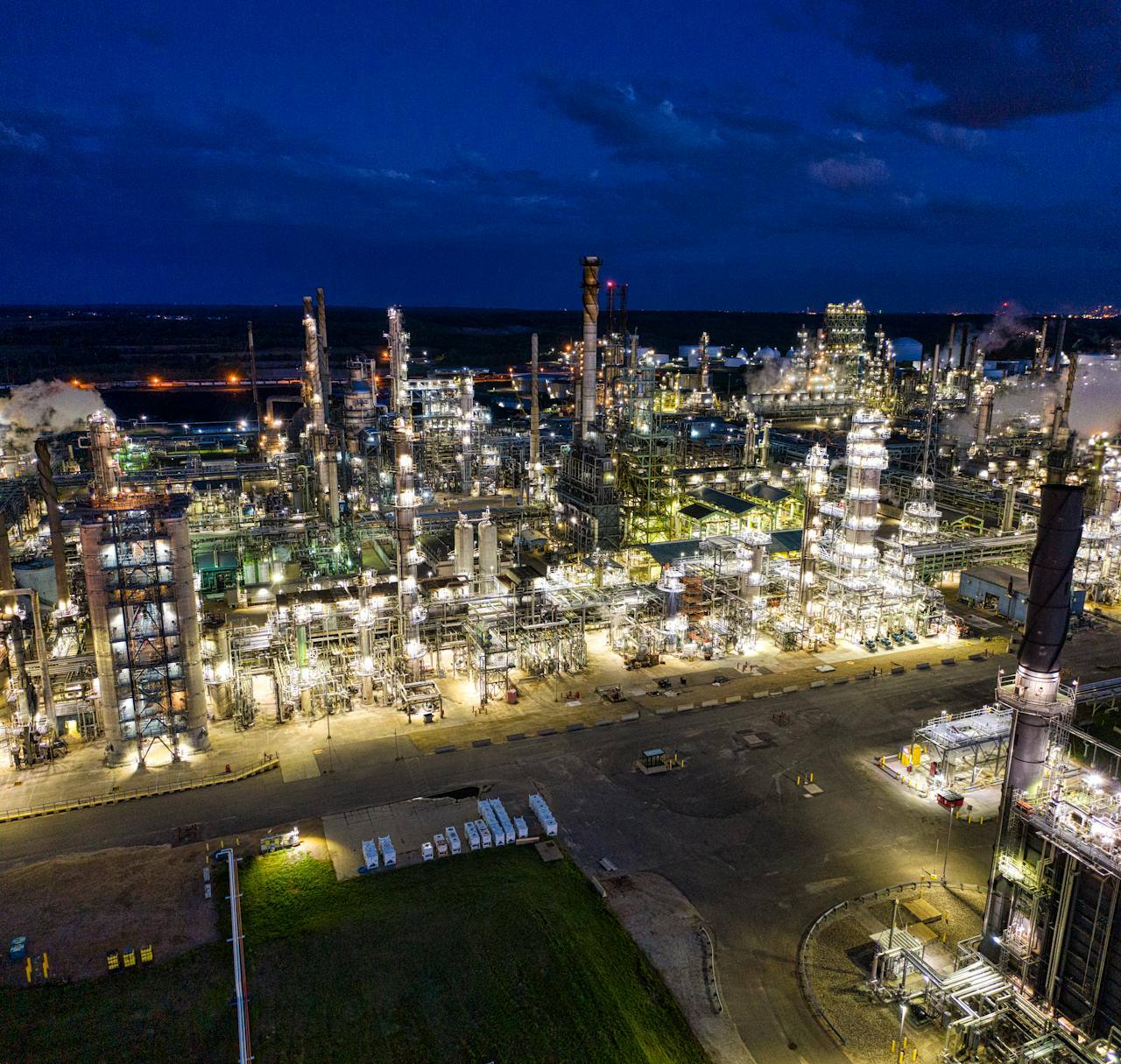 Aerial view of a refinery complex illuminated at night.